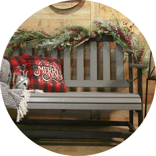 Black and gray bench with holiday pillows and decor sitting on it.